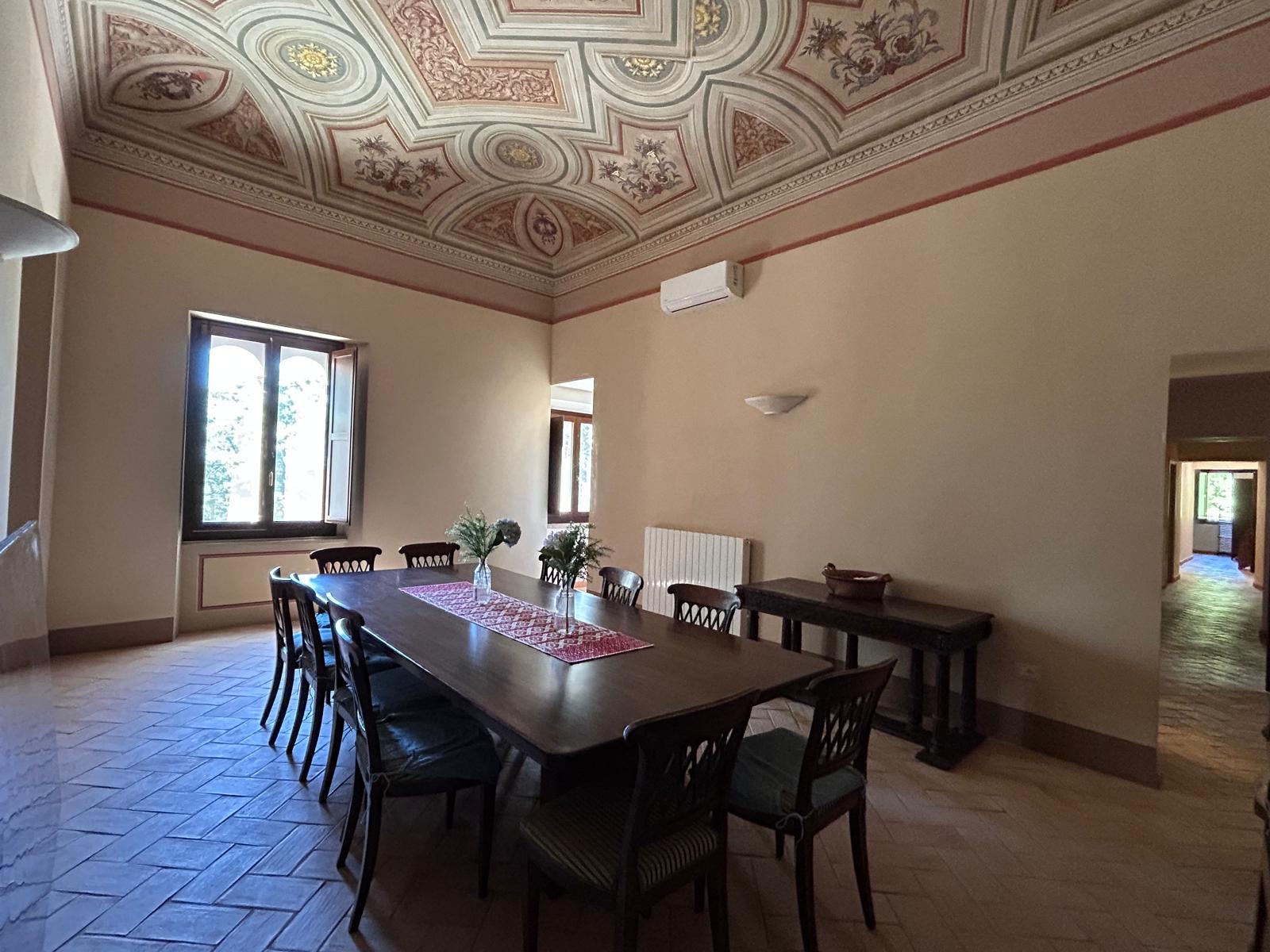 Binnenunit discreet geplaatst onder een fresco plafond in een historische eetkamer