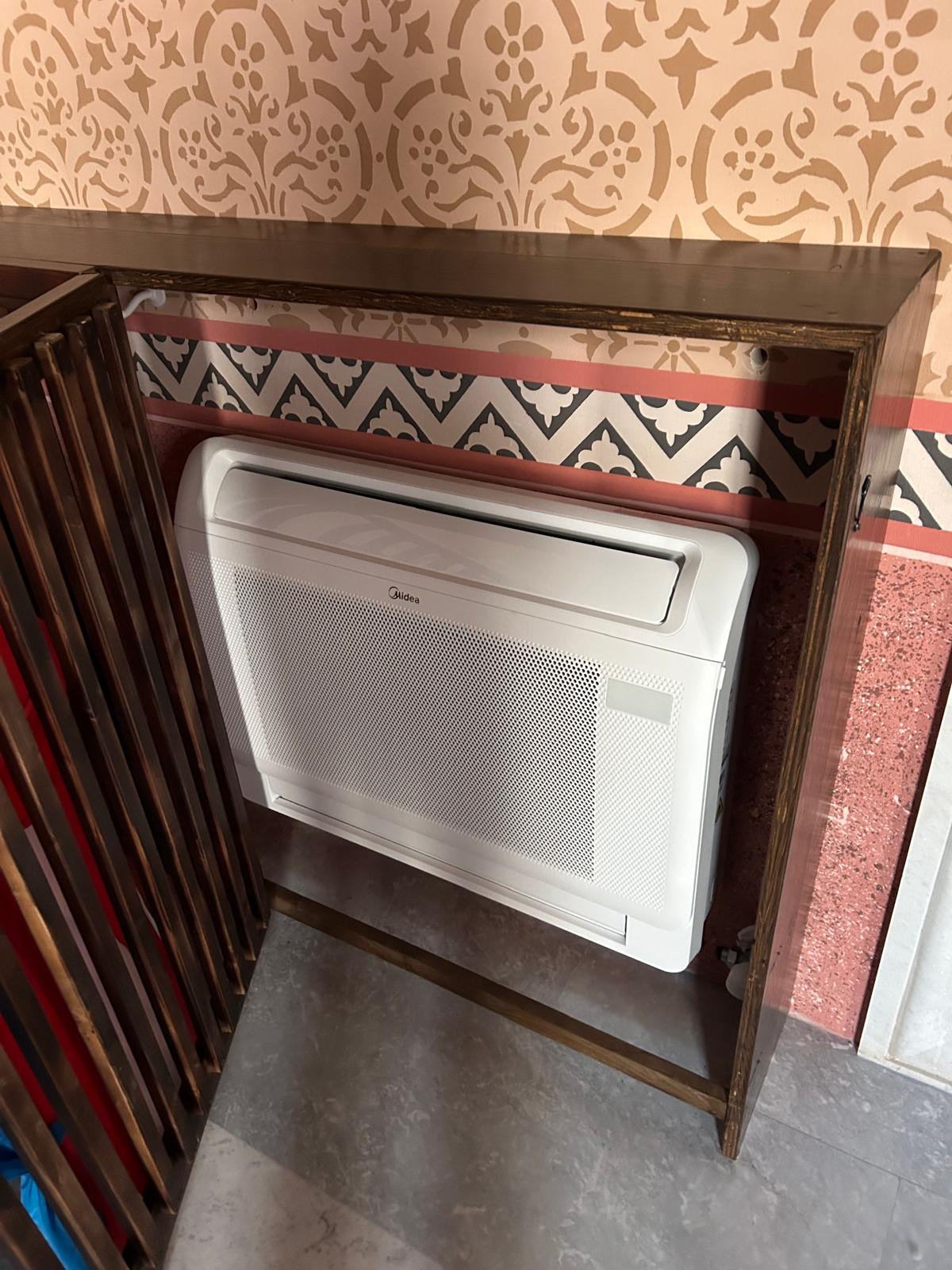 Vloermodel airco volledig weggewerkt achter een houten ombouw